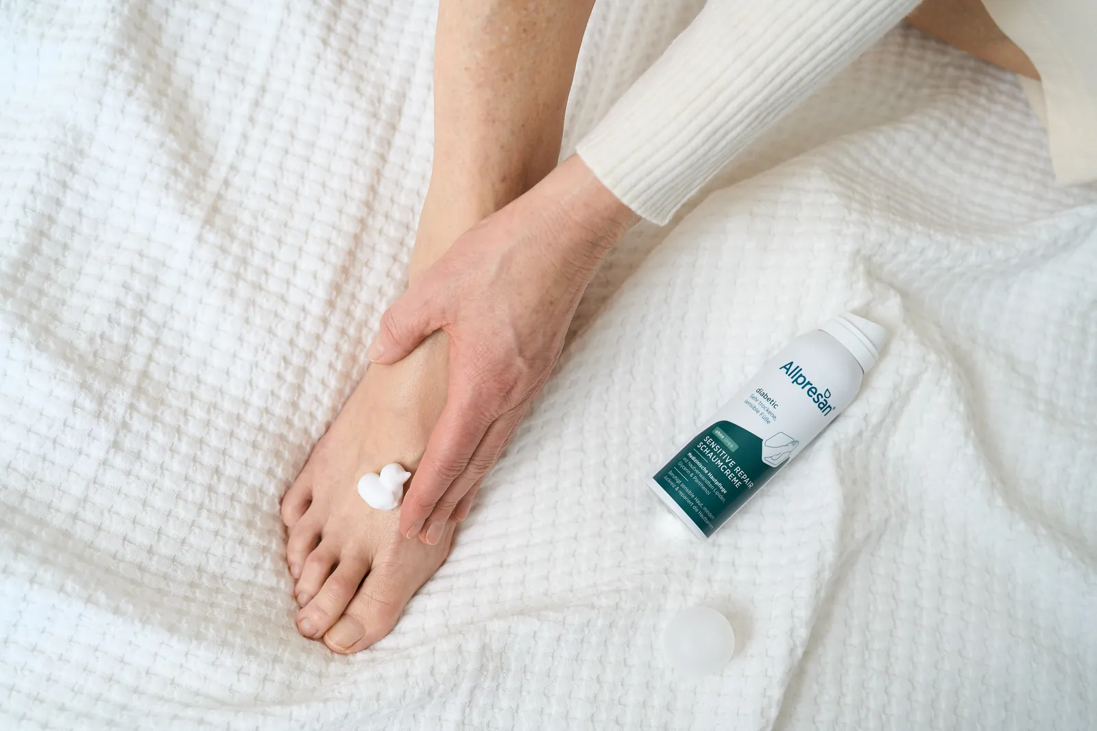 Eincremen des Fußes mit Allpresan Schaum Creme
